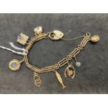 Jewellery: Yellow metal three bar gate bracelet with eight assorted charms attached having a padlock