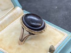 Jewellery: Yellow metal 1979 ring set with an oval cabouchon cut banded agate, tests as 9ct gold.