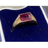 Jewellery: Yellow metal ring with an emerald cut ruby, tests as 18ct gold. Ring size L½. 2.7g.