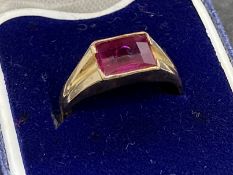 Jewellery: Yellow metal ring with an emerald cut ruby, tests as 18ct gold. Ring size L½. 2.7g.