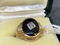 Jewellery: Yellow metal oval signet ring set with onyx and a rose cut diamond, tests as 18ct gold.