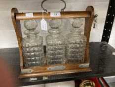 Late 19th/early 20th cent. Oak Tantalus with three decanters and keys.