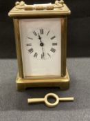 Clocks: French brass carriage clock, white enamel face, Roman numerals. 4½ins.