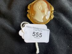 Jewellery: Yellow metal oval brooch 47.5mm x 43.5mm, with scroll and leaf border set with a shell
