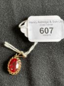 Jewellery: Yellow metal pendant set with an oval synthetic ruby, tests as 14ct gold. Weight 3.9g.