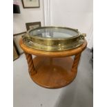 20th cent. Brass porthole mounted into a coffee table in the marine style. 22ins.
