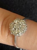 Jewellery: White metal ring set with seven brilliant cut diamonds as a floral cluster, estimated