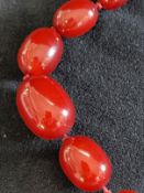 Jewellery: Necklet of sixty-nine graduated oval amber beads, ranging from 30mm x 21mm to 10mm x 4mm.