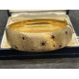 Hallmarked Jewellery: 9ct gold hinged bangle, the front section satin finished and set with seven