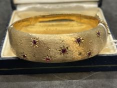 Hallmarked Jewellery: 9ct gold hinged bangle, the front section satin finished and set with seven
