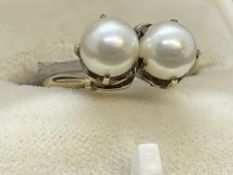 Jewellery: Yellow metal crossover ring set with two cultured pearls, tests as 9ct gold. Ring size