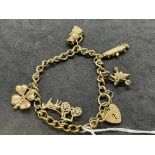 Hallmarked Jewellery: 9ct gold curb link charm bracelet with five assorted charms attached. Total