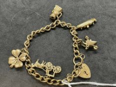 Hallmarked Jewellery: 9ct gold curb link charm bracelet with five assorted charms attached. Total