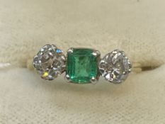 Jewellery: Yellow and white metal ring claw set with a single rectangular cut emerald, estimated