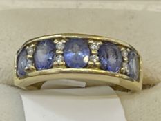 Jewellery: 18ct gold nine stone half hoop set with five oval cut tanzanite, estimated weight of (5)