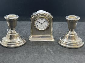 Silver: Small mantel clock and pair of mantel sticks. Gross weight 15.6oz.