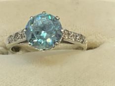 9ct white gold ring set with a single aquamarine, estimated weight 2.00ct, with three diamonds in