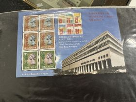 Three albums containing an eclectic mix of stamp related collectables relating to Hong Kong from