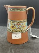 Christopher Dresser for Watcombe Pottery terracotta jug decorated with enamel band depicting