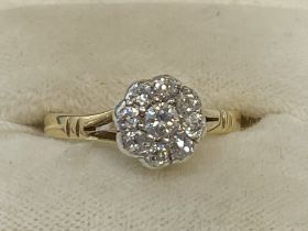 Jewellery: Yellow and white metal ring set with nine brilliant cut diamonds as a floral cluster