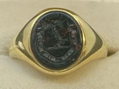 Jewellery: Yellow metal oval signet ring set with a seal engraved bloodstone, tests as 18ct gold.