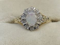 Jewellery: 9ct gold cluster ring set with an oval cut opal, estimated weight 1.25ct,