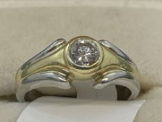 Jewellery: Yellow and white metal ring set with a single 0.25ct brilliant cut diamond