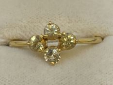 Jewellery: Yellow metal ring set with four round yellow sapphires in a four leaf clover style