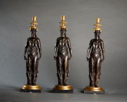 SET OF THREE EMPIRE STYLE GILT BRONZE AND PATINATED CANDLESTICKS Paris, vers 1860