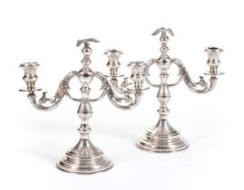 A PAIR OF SILVER TWO-LIGHT CANDELABRA SURMOUNTED BY AN EAGLE