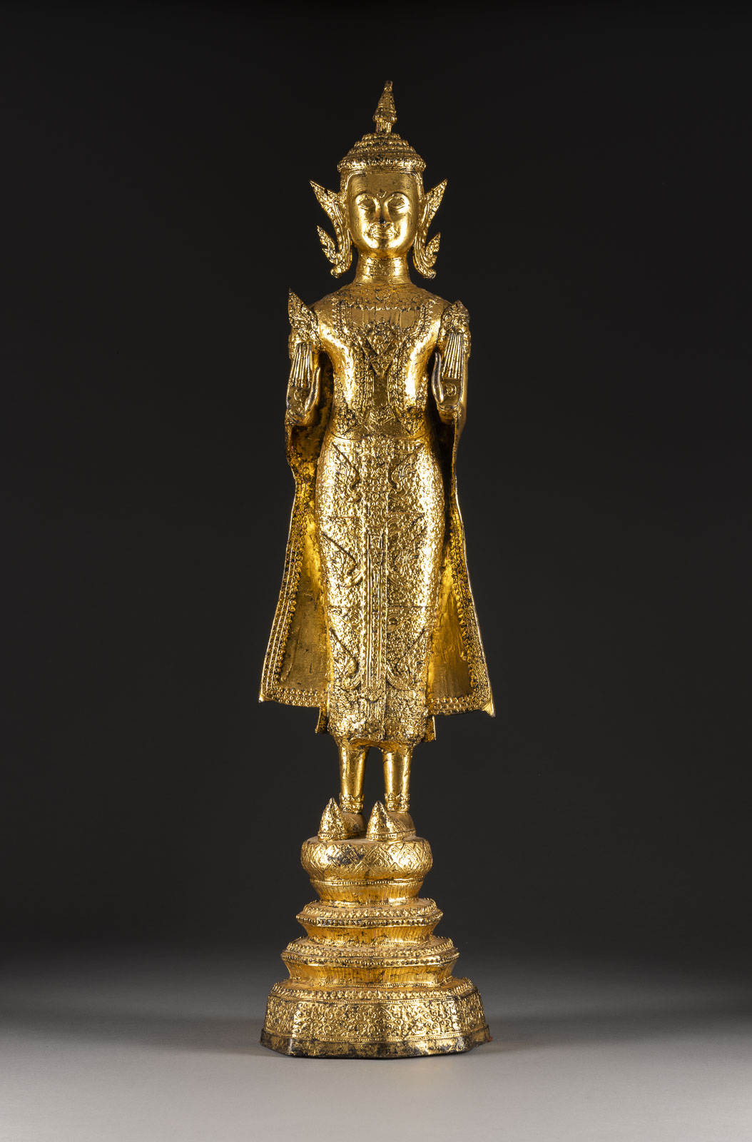 EINE VERGOLDETE STEHENDE FIGUR VON BUDDHA AUS BRONZE