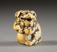 EIN GESCHNITZTES NETSUKE EINES SHISHI AUS ELFENBEIN