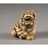 EIN GESCHNITZTES NETSUKE EINES SHISHI AUS ELFENBEIN