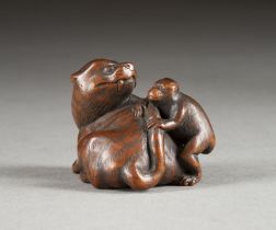 EIN FEINES HOLZGESCHNITZTES NETSUKE EINES TIGERS MIT AFFEN