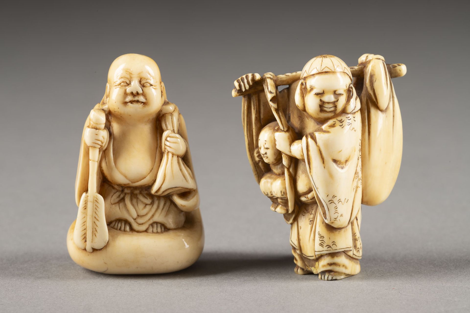 ZWEI GESCHNITZTE NETSUKE VOM HOTEI AUS ELFENBEIN