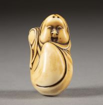 EIN GESCHNITZTES NETSUKE VON OKAME AUS ELFENBEIN