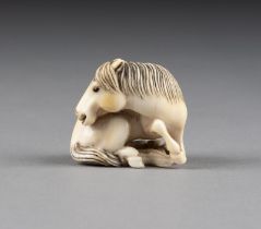 EIN GESCHNITZTES NETSUKE EINES PFERDES AUS ELFENBEIN