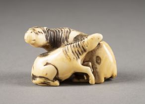 EIN GESCHNITZTES NETSUKE EINES PFERDES UND FOHLEN AUS ELFENBEIN