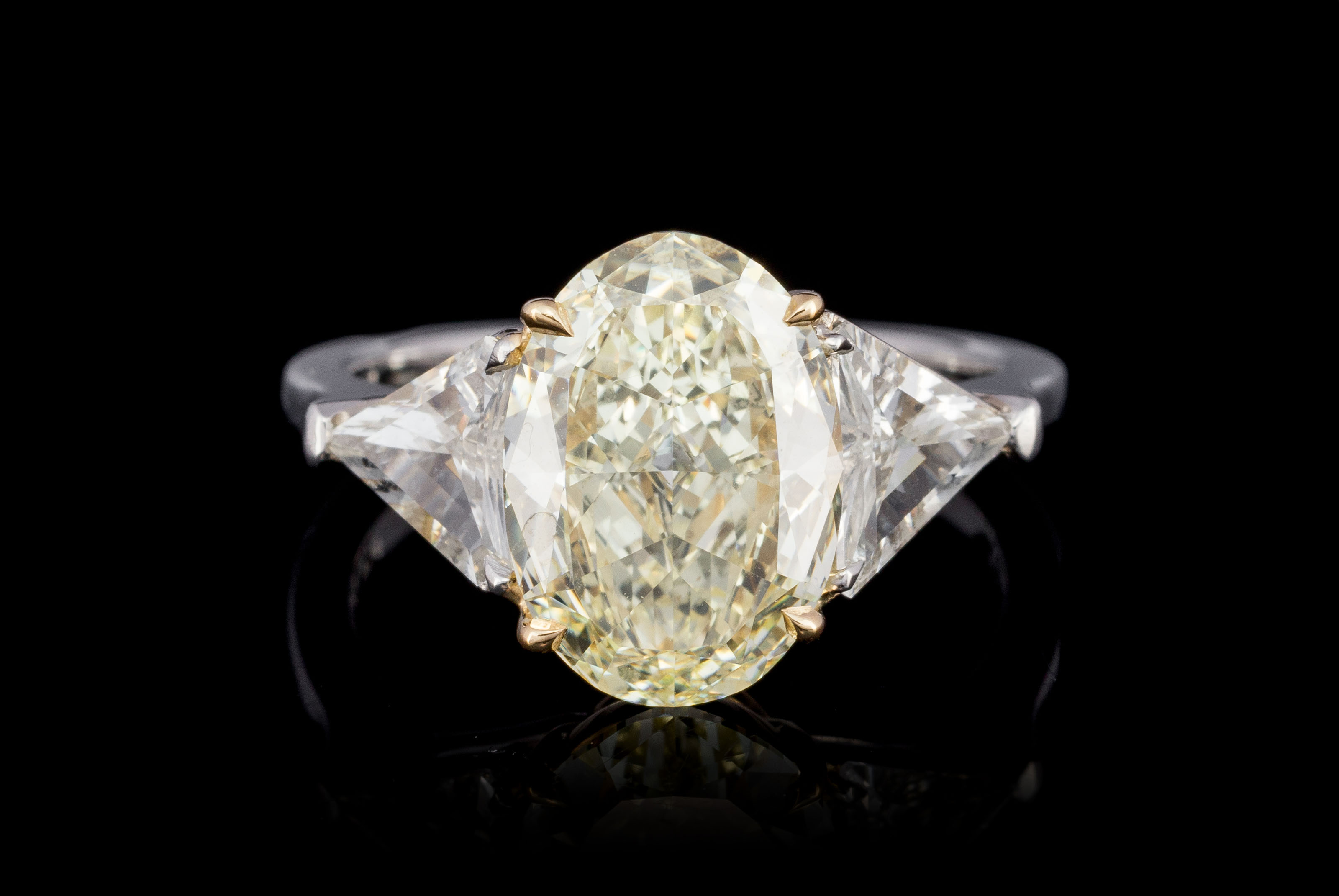 Bague platine et or 750 sertie d'un diamants taille ovale de 3.25 carats épaulé de deux diamants tai