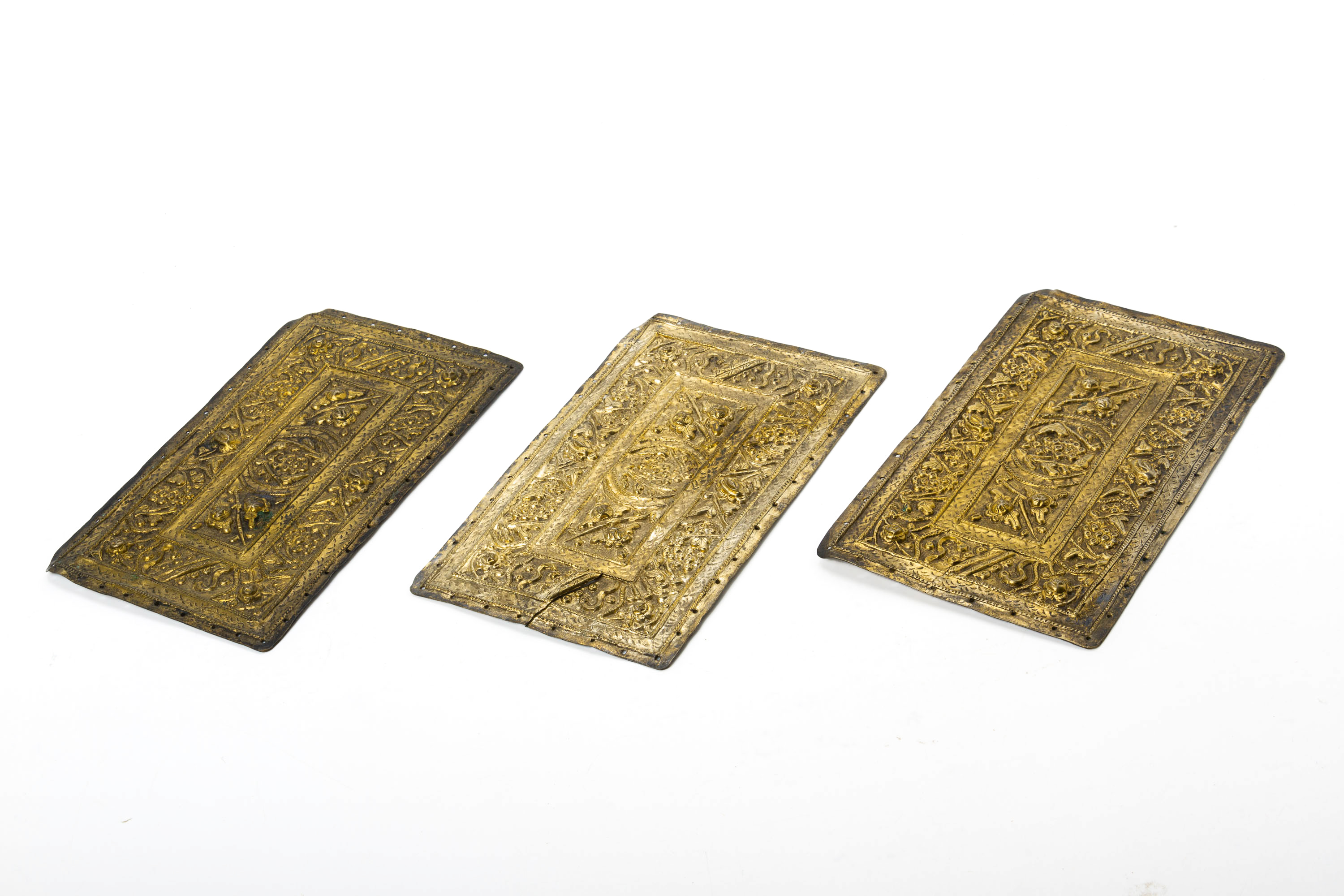 A SET OF THREE REPOUSSE SILVER GILT PILLOW ENDS - Image 2 of 4