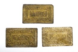 A SET OF THREE REPOUSSE SILVER GILT PILLOW ENDS