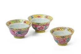 THREE PINK GROUND FAMILLE ROSE 'PHOENIX' TEA BOWLS