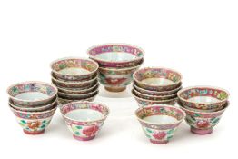 A GROUP OF EIGHTEEN WHITE GROUND FAMILLE ROSE TEA CUPS