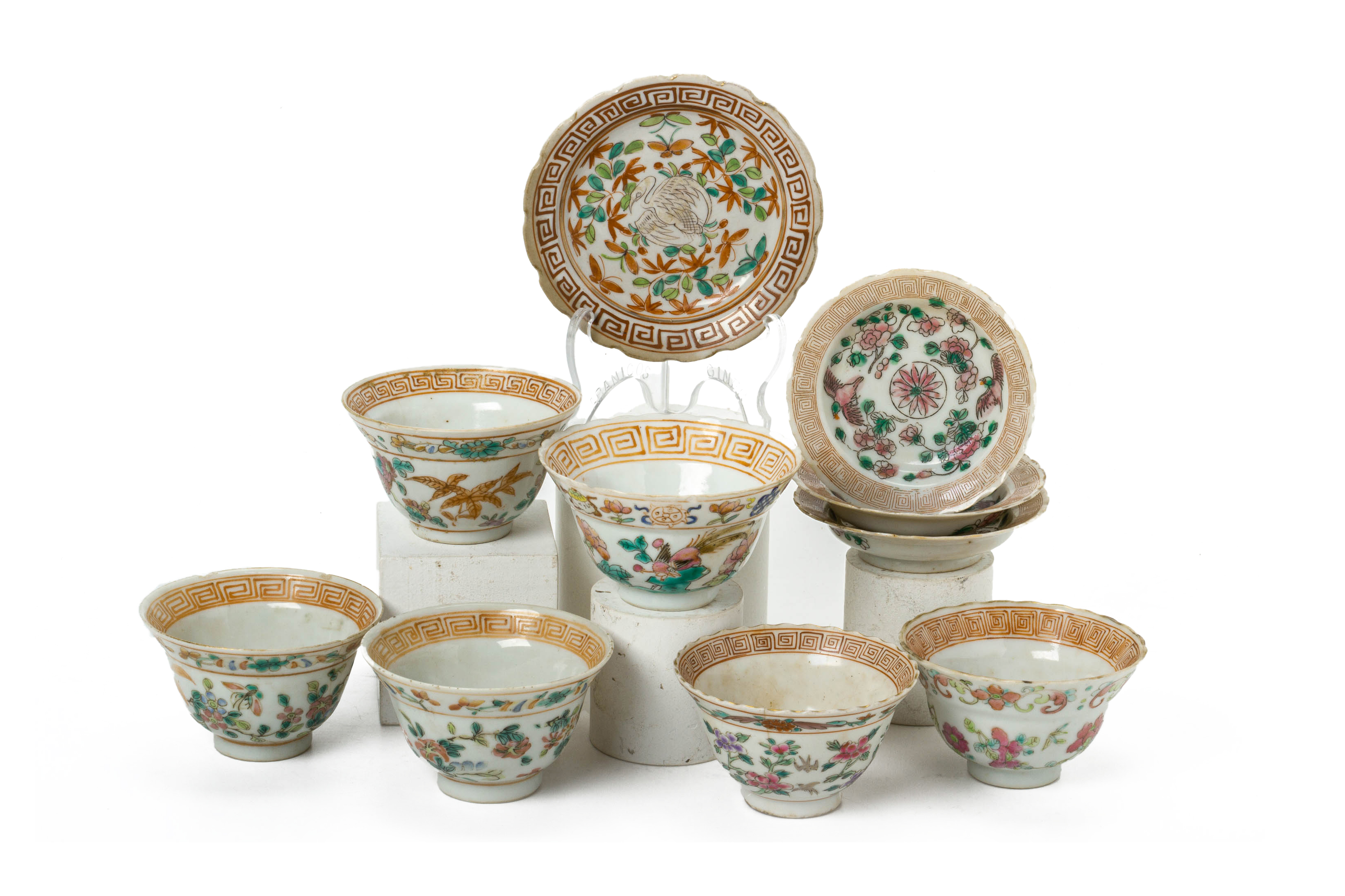 A GROUP OF WHITE GROUND FAMILLE ROSE TEA BOWLS AND SAUCERS