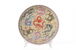 A LARGE YELLOW GROUND FAMILLE ROSE DRAGON DISH