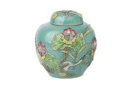 A RELIEF MOULDED TURQUOISE GROUND JAR AND COVER