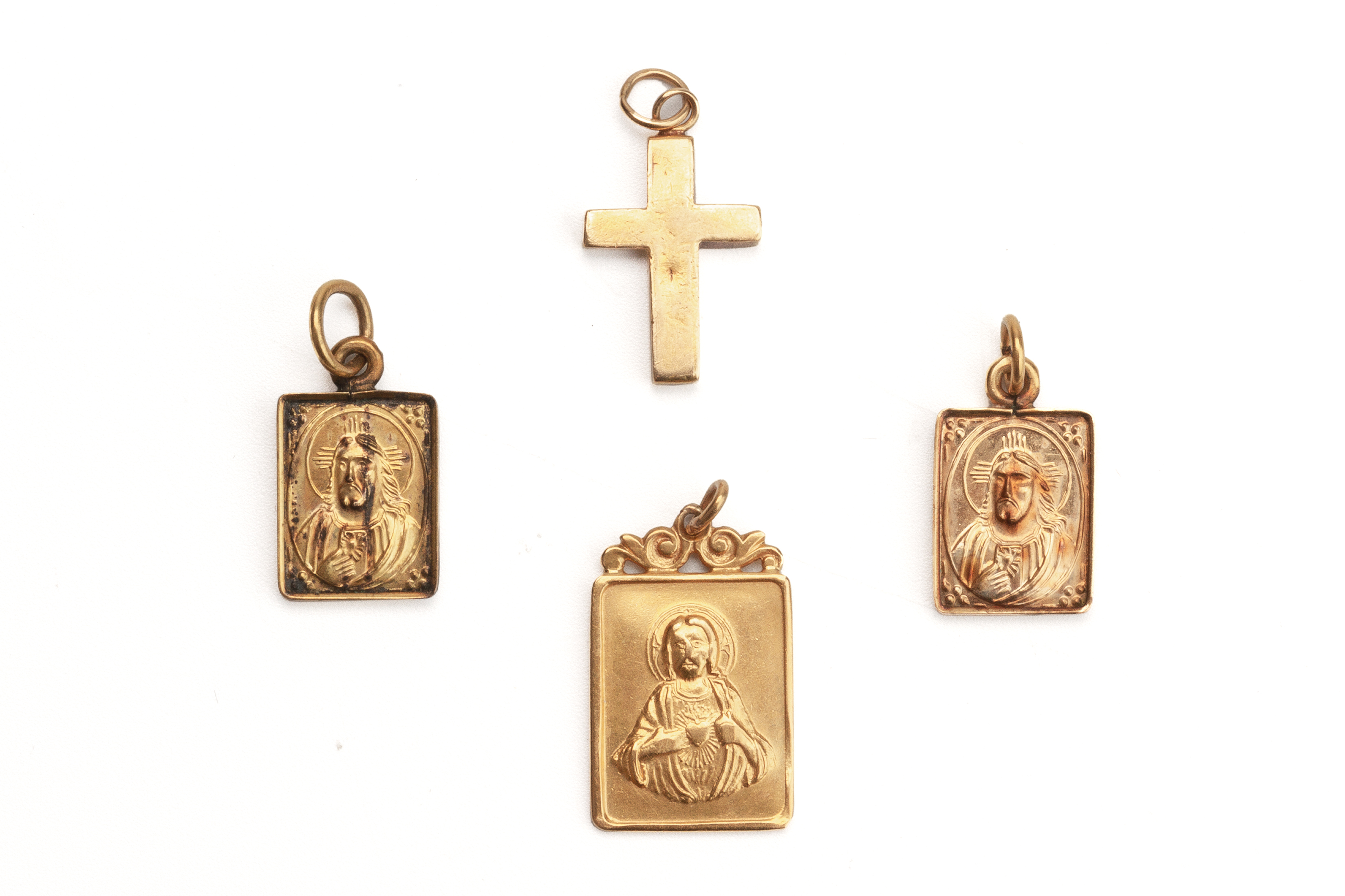 A GROUP OF FOUR GOLD PENDANTS