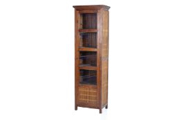 A NARROW GLAZED TEAK CABINET