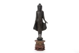 A SOUTHEAST ASIAN CARVED WOOD STANDING BUDDHA
