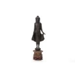 A SOUTHEAST ASIAN CARVED WOOD STANDING BUDDHA